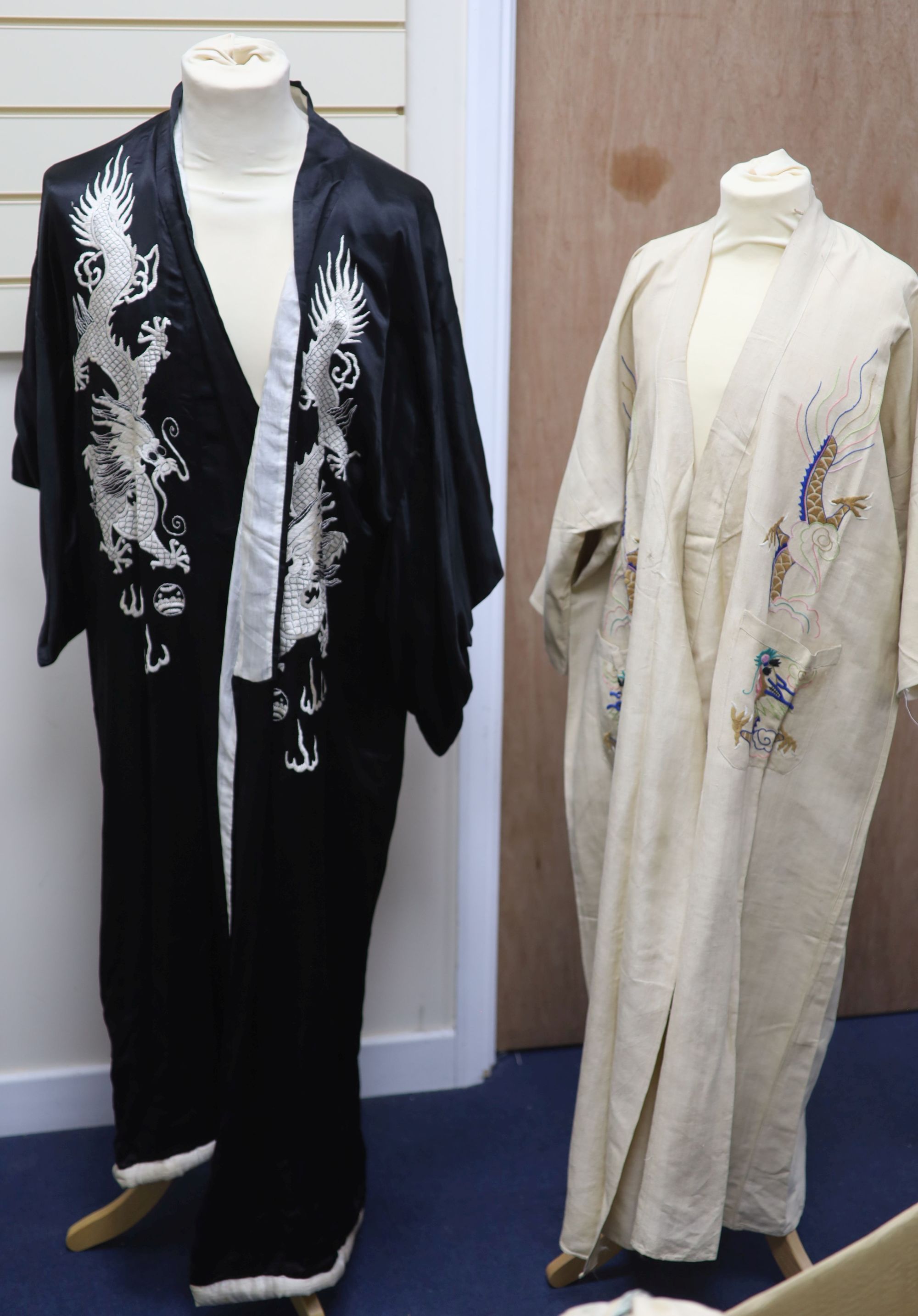 A Japanese black silk satin kimono embroidered with a white silk dragon, 133cm long and a cream silk multi-coloured embroidered dragon